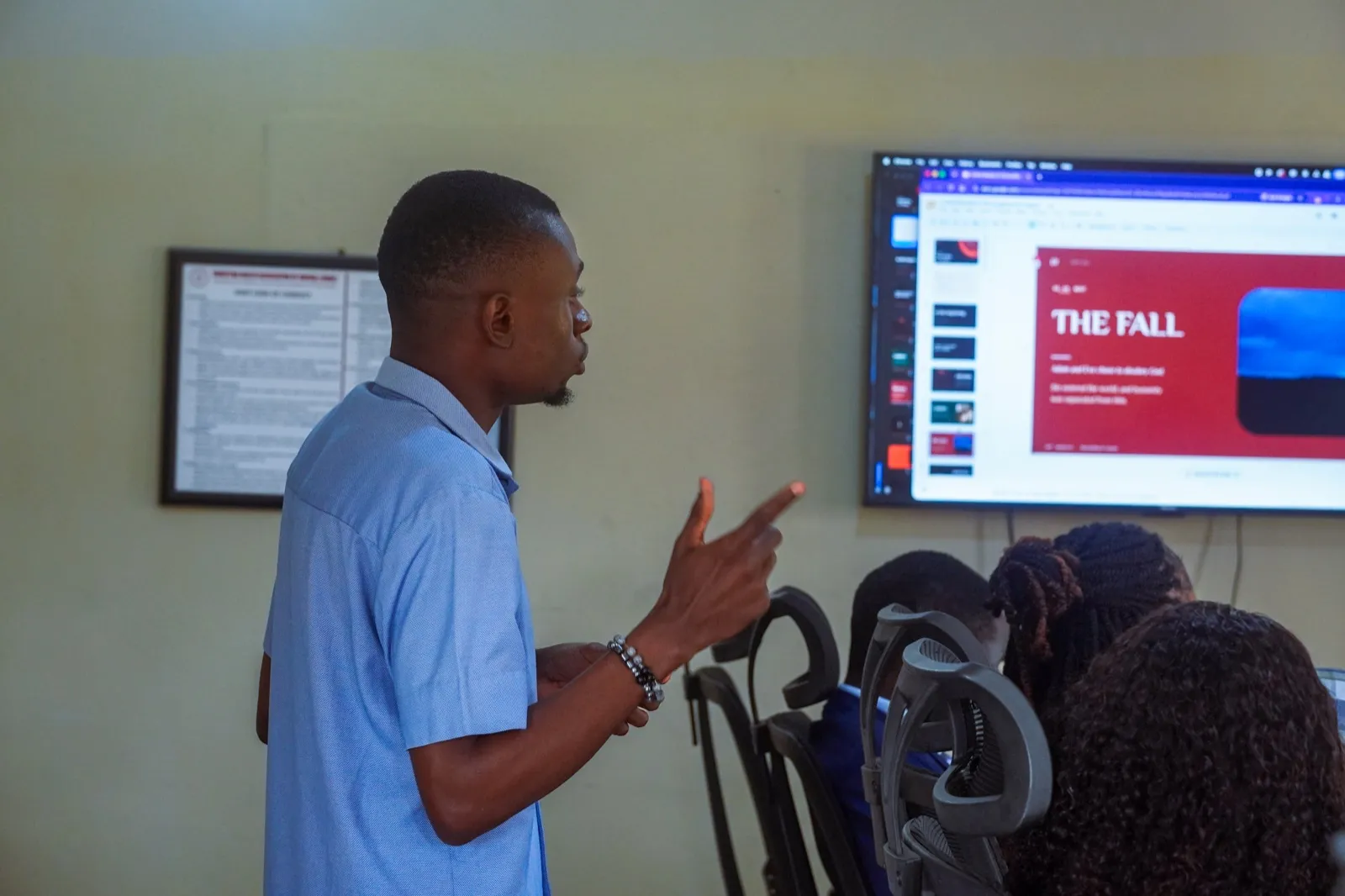 A facilitator gestures toward a presentation screen during a session.