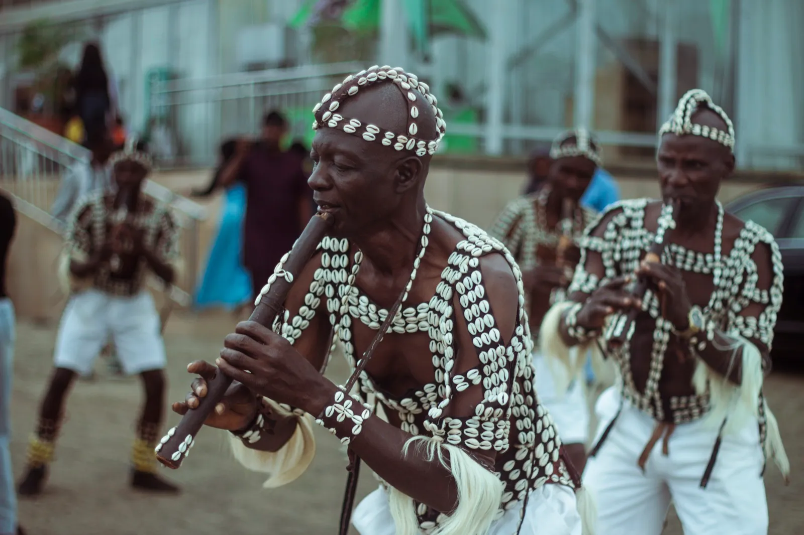 An experienced flautist performs while fellow musicians stand behind him.